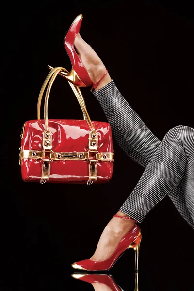 şık kırmızı çanta şık yüksek topuklu ayakkabı üzerinde asılı.