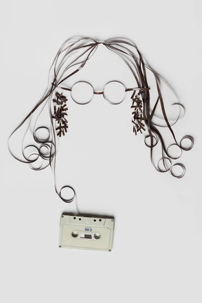 明るい背景上に髪のメガネの顔を形成テープでテープ カセットの作られた美しいイメージ — ストック写真