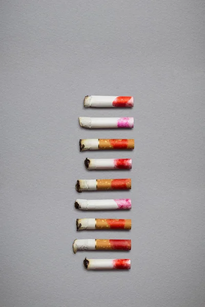 创意静物画不同的香烟存根 Stub 与灰色的背景上的口红印 — 图库照片