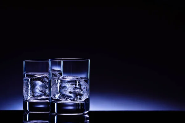 Dois Copos Vodka Com Cubos Gelo Contra Fundo Brilho Azul — Fotografia de Stock