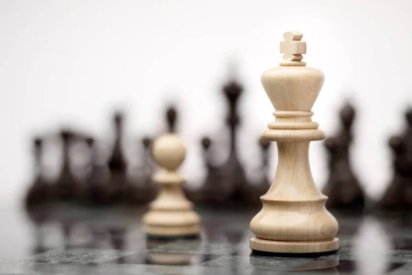 リーダーシップおよび勇気の概念 チェス盤に白のキングに対して滞在白い木製一つの駒 — ストック写真