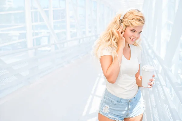 Schöne Junge Frau Mit Musikkopfhörern Die Mit Einer Kaffeetasse Zum — Stockfoto