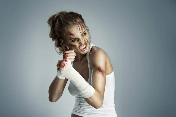 攻击战斗机女与血腥绷带戴她的拳头 站在拳击防御位置 准备战斗中性灰色演播室背景上的瘀伤 — 图库照片