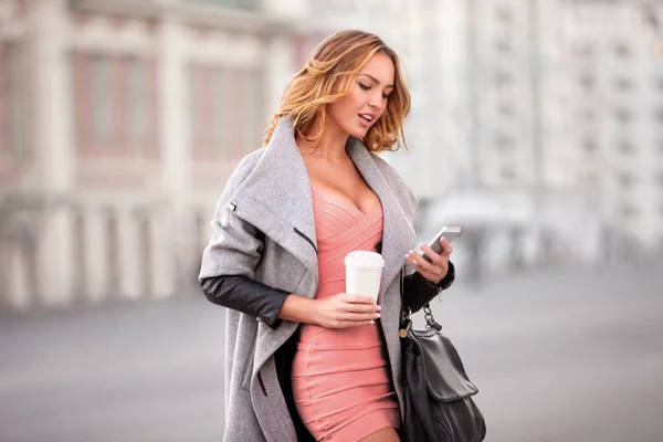 Affärskvinna Kontrollera Post Mobiltelefon Och Håller Kaffekopp Mot Stadsbilden — Stockfoto