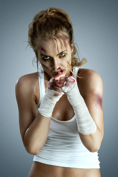 攻击战斗机女与血腥绷带戴她的拳头 站在拳击防御位置 准备战斗中性灰色演播室背景上的瘀伤 — 图库照片