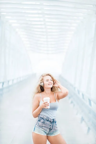 Piękna Młoda Kobieta Muzyka Słuchawki Stojąc Moście Przy Filiżance Kawy — Zdjęcie stockowe