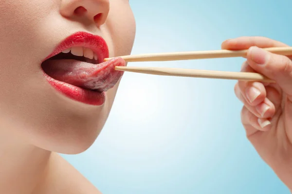 Foto Menina Rosto Inferior Com Comer Paus Língua Hoding — Fotografia de Stock