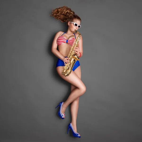 美しいピンナップ少女レトロなビキニとサングラス 黒板背景にジャズ サックスを演奏のトップ ビュー — ストック写真