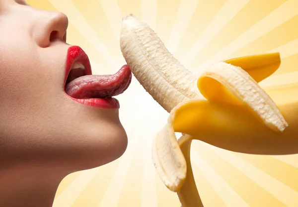 一个热女孩的脸 是舔半去皮黄色香蕉在彩色抽象卡通风格背景 — 图库照片