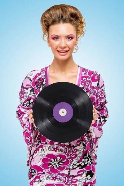 青色の背景色に彼女の手でレトロなビニール レコードと幸せなファッショナブルなヒッピー主婦のカラフルな写真 — ストック写真