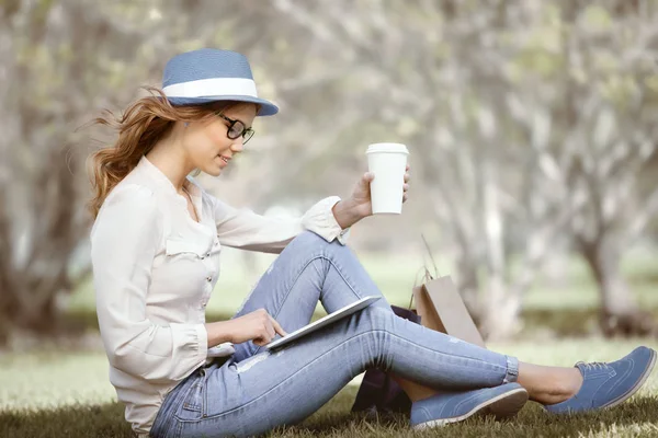 Mujer Joven Feliz Una Taza Café Desechable Sentado Hierba Uso — Foto de Stock