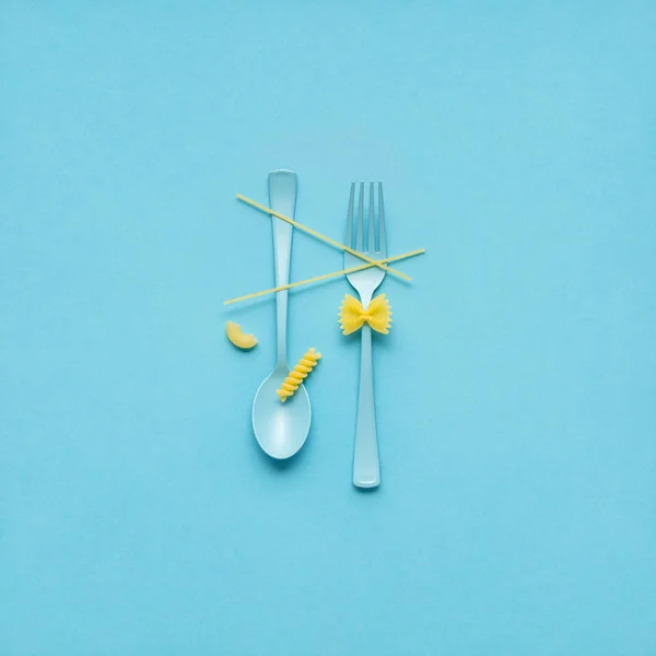 创意静物餐叉和勺子的照片在蓝色背景的生面团 — 图库照片