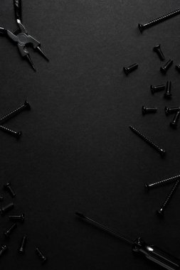 Yaratıcı konsept fotoğraf boyalı araçları ve siyah arka plan üzerine çivi.