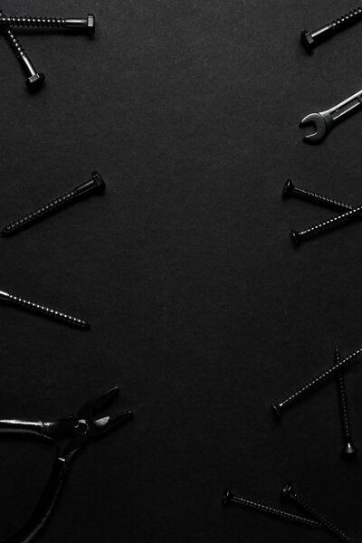 Creative concept photo of painted tools and nails on black background.