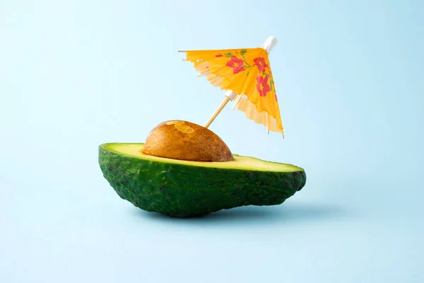 青い背景に傘とアボカドドリンク飲料ジュースカクテルの創造的な食品健康食のコンセプト写真 — ストック写真