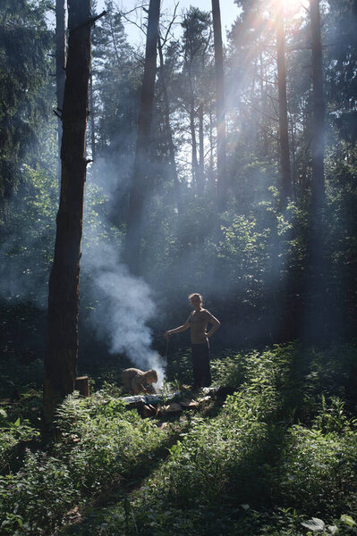 Пикник в лесу. Генеральный план мамы и сына у костра в лесу
