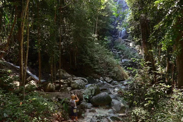 Pequeño viajero toma una foto de una cascada de la selva . —  Fotos de Stock