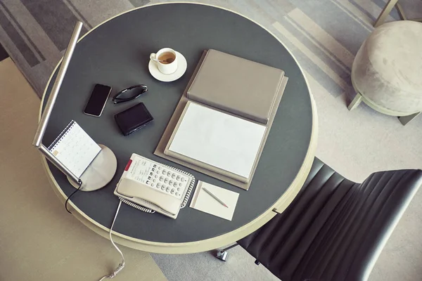 Lugar de trabajo con mesa de trabajo redonda de cuero, silla de cuero y otro objeto de negocios — Foto de Stock