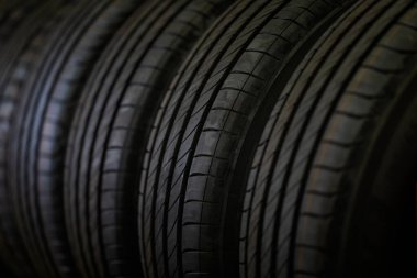 Lastik yığını arka planı ve seçici odak. Araba lastikleri depoda..