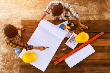 En üst düzey inşaat ekibi mühendis ve mimarlardan oluşan bir ekip çalışıyor, toplanıyor, tartışıyor, tasarlıyor, planlıyor, ölçüyor fabrika zeminindeki inşaat alanının planlarını oluşturuyor..
