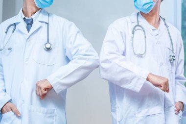 Dirsek çarpması. Coronavirus 'un yayılmasını önlemek için yeni bir roman. İki doktor arkadaş hastanede çıplak elle buluşuyor. Onun yerine dirseklerini çarpıyorlar. Yeni normal