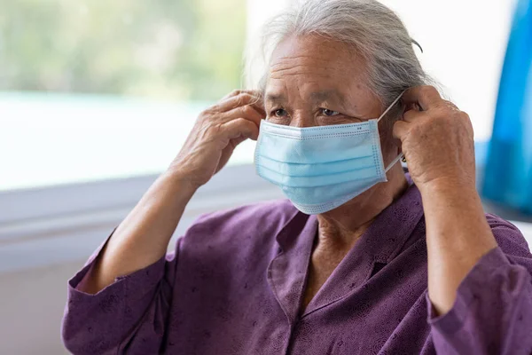 Senior asian woman wearing face mask during corona virus and flu outbreak. Disease and illness protection. the aging female patient that is at risk for infection corona virus covid-19.