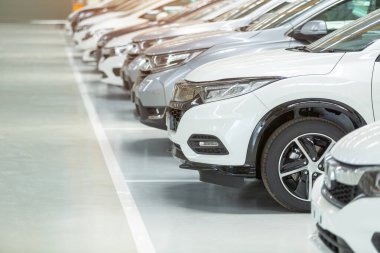 Satılık arabalar, otomotiv endüstrisi, araba galerisi otoparkı. Gıcır gıcır yeni araçlar yeni araba servisinin epoksi katında yeni sahiplerini bekliyor.