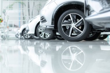 Satılık arabalar, otomotiv endüstrisi, araba galerisi otoparkı. Gıcır gıcır yeni araçlar yeni araba servisinin epoksi katında yeni sahiplerini bekliyor.