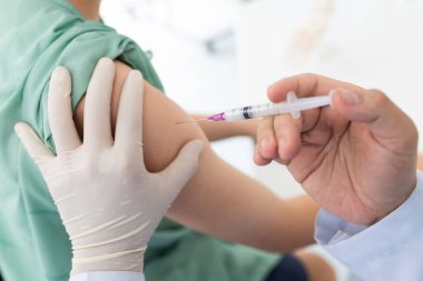 Koluna grip aşısı, koronavirüs aşısı, covid-19 aşısı aşısı aşısı yapılan bir hastanın omzuna aşı yapan bir doktor hastaya yakından bakın.