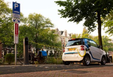 Hollanda, Amsterdam 'daki şarj istasyonunda ev arabası veya elektrikli araba