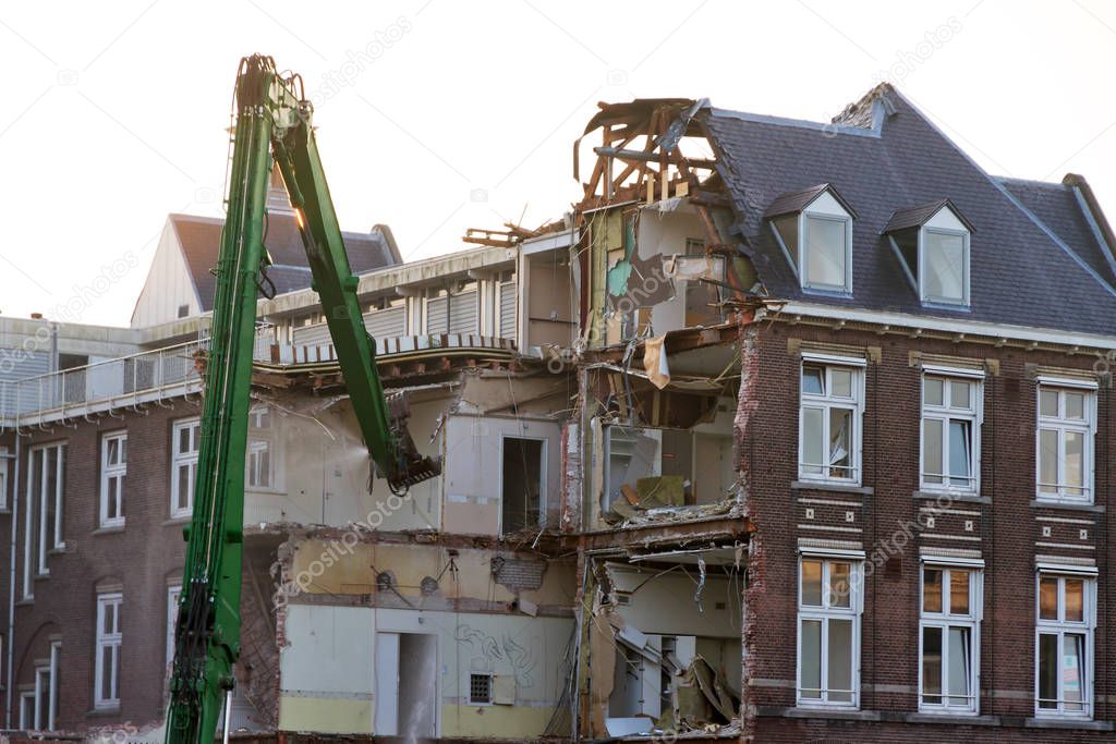 crane demolishes a house  on background