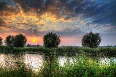Hollanda 'da nehrin üzerinde güzel bir gün batımı .