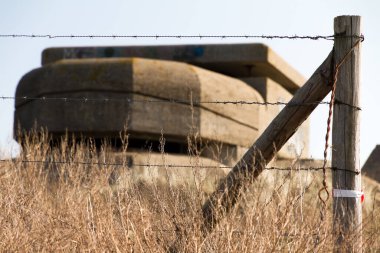 Hollanda, Ijmuiden 'da dikenli tellerin arkasındaki eski ww2 sığınağı.