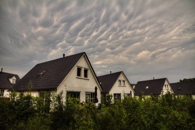 Mammatocumulus Hollanda 'daki güzel kırsal evler üzerinde gök gürültüsü bulutları
