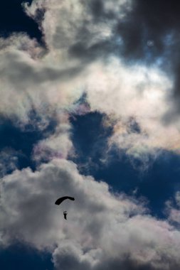 Paraşütçü ve dramatik mavi gökyüzünde kaygı verici beyaz bulutlar