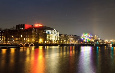 AMSTERDAM, NETHERLANDS - 30 Haziran 2014: Amsterdam, Hollanda 'daki Amstel nehrindeki tiyatronun güzel manzarası, bulutlu güneşli bir yaz günü, 30 Haziran 2014