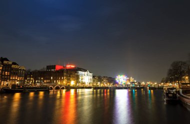 AMSTERDAM, NETHERLANDS - 30 Haziran 2014: Amsterdam, Hollanda 'daki Amstel nehrindeki tiyatronun güzel manzarası, bulutlu güneşli bir yaz günü, 30 Haziran 2014