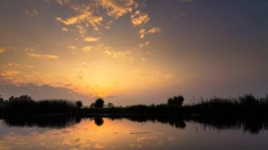 Gölün üzerinde canlı bir gün batımı.