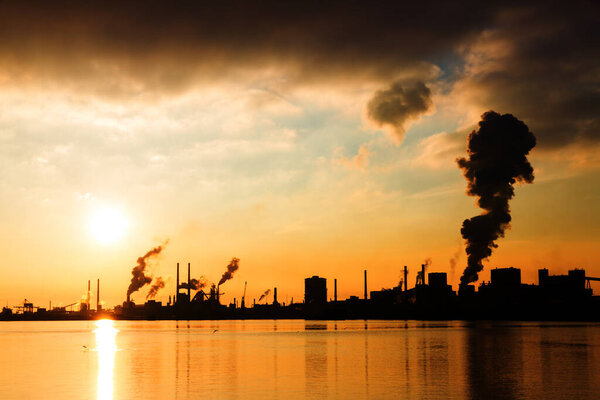 Sunset view of the heavy industry with smoking chimneys in IJmuiden, the Netherlands
