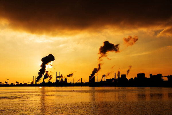Sunset view of the heavy industry with smoking chimneys in IJmuiden, the Netherlands