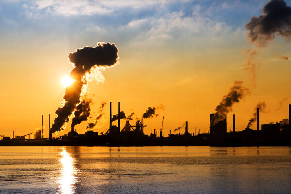 Sunset view of the heavy industry with smoking chimneys in IJmuiden, the Netherlands