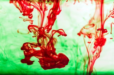 Bir damla kırmızı kremanın küçük bir adamın vurulması şeklinde karanlık suya düşüşünün güzel bir görüntüsü.