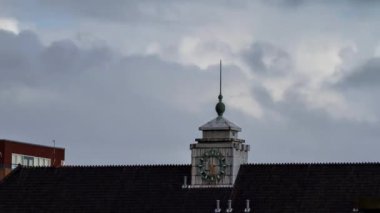 Hollanda, Amsterdam 'da gün batımında bir binanın saatine zum yapmak çok güzel bir HD zaman aşımı.