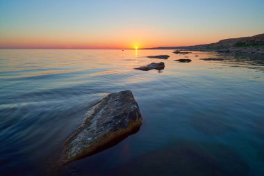Gün batımında taşlarla Denizi'nin kıyısında. Hazar Sea.The Hazar Denizi kıyısında alanına göre dünyadaki en büyük kapalı iç su organıdır.