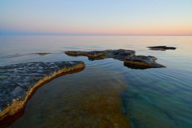 Gün batımında taşlarla Denizi'nin kıyısında. Hazar Sea.The Hazar Denizi kıyısında alanına göre dünyadaki en büyük kapalı iç su organıdır.