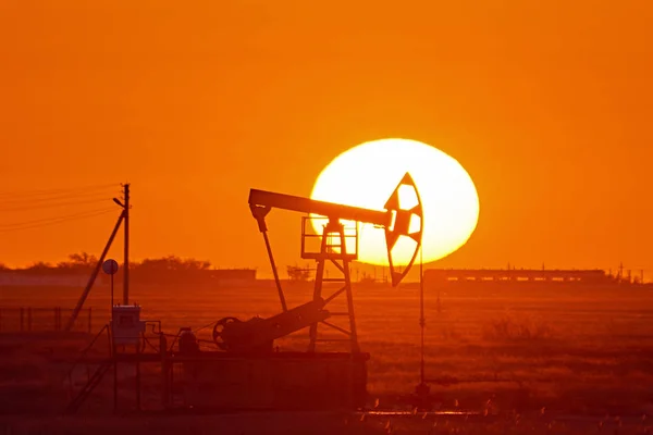 夕阳背景下的 Pumpjack Pumpjack 是在油井中往复活塞泵的地上驱动 这种安排通常用于陆上油井生产少许石油 Pumpjacks 在盛产石油的地区很常见 — 图库照片