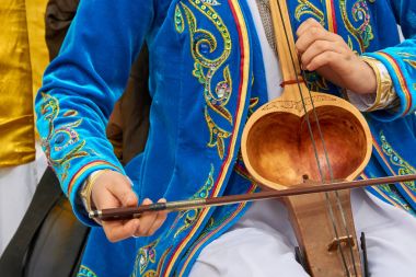 Bir müzik aleti kobyz oynuyor. Kobyz veya ql-kobz eski bir kazak yaylı çalgılar var. At kılı yapılan iki dizeleri vardır. Rezonans kavite genellikle keçi deri ile kaplıdır. 