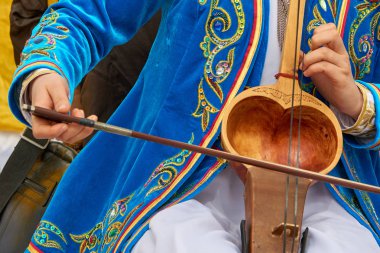 Bir müzik aleti kobyz oynuyor. Kobyz veya ql-kobz eski bir kazak yaylı çalgılar var. At kılı yapılan iki dizeleri vardır. Rezonans kavite genellikle keçi deri ile kaplıdır. 