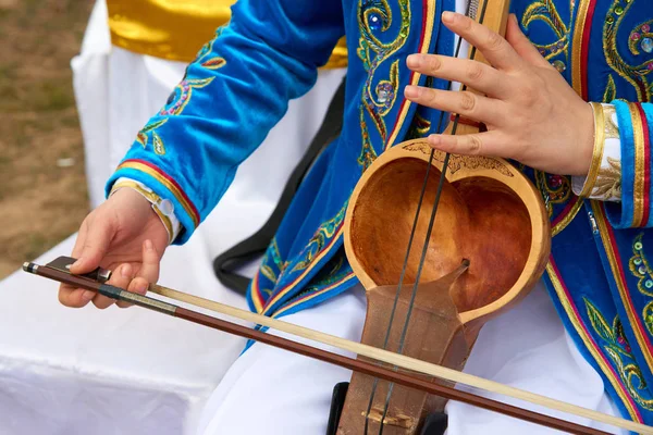 Bir müzik aleti kobyz oynuyor. Kobyz veya ql-kobz eski bir kazak yaylı çalgılar var. At kılı yapılan iki dizeleri vardır. Rezonans kavite genellikle keçi deri ile kaplıdır. 