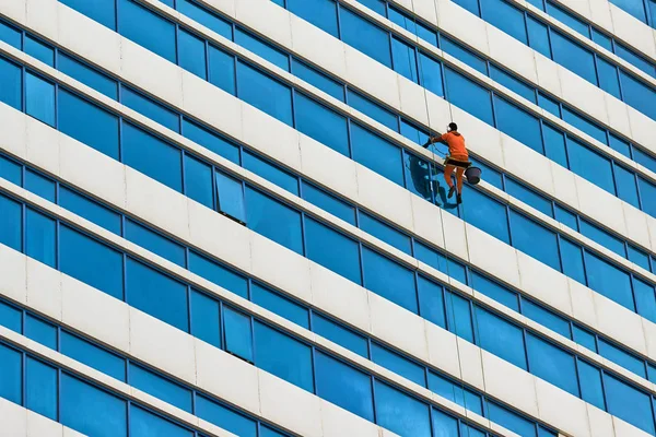Industrial climber wash the windows of skyscraper. A modern skyscraper.